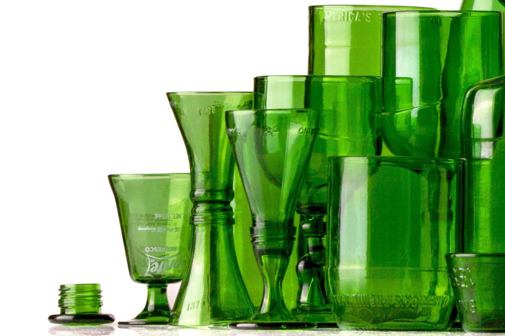 Collection of green glassware including cups and a carafe on a white background
